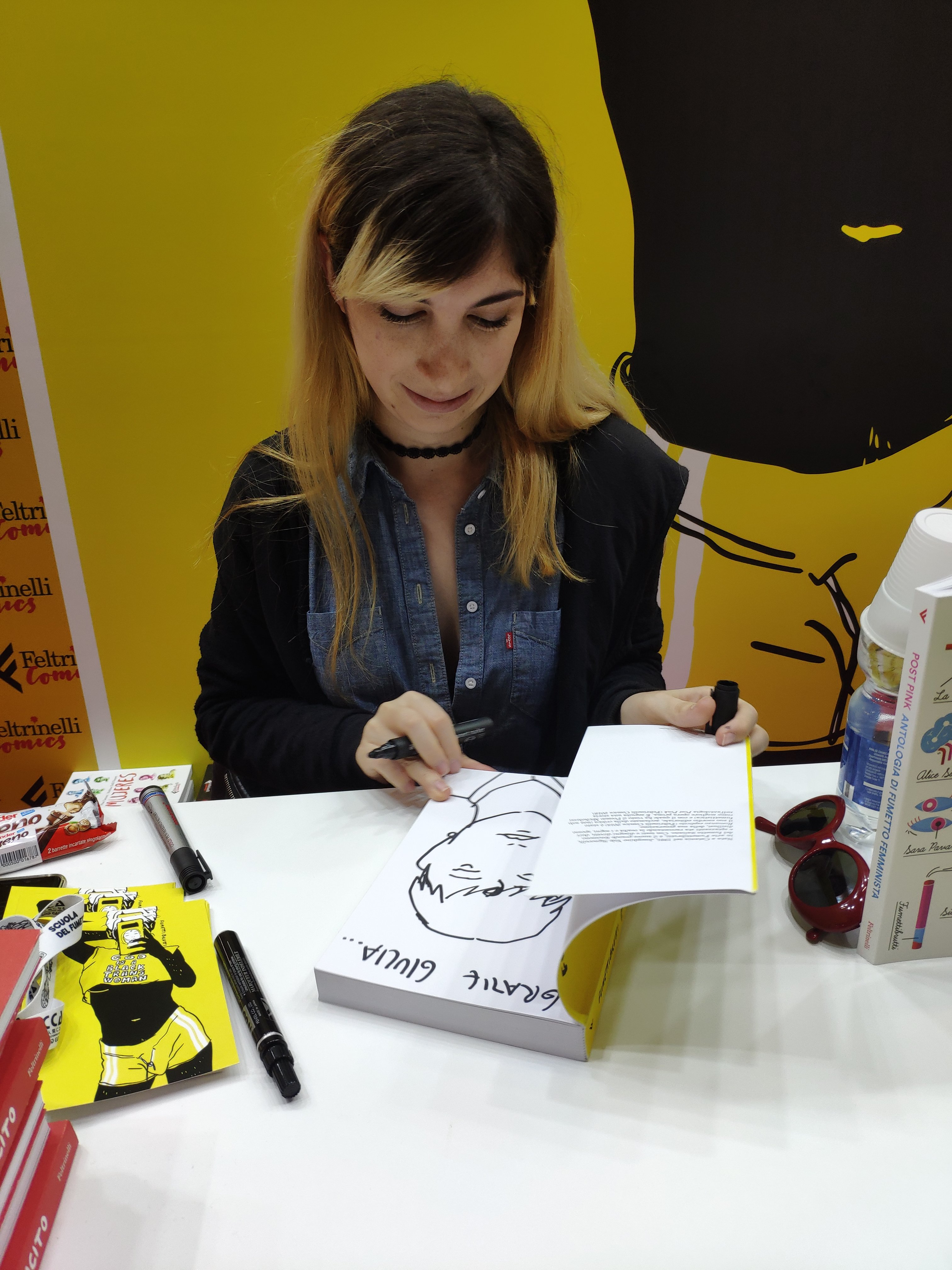 Mio Caro Fumetto - Lucca Comics & Rain 2019 - Josephine Yole Signorelli mentre disegna la dedica sulla mia copia di P., la mia adolescenza trans.